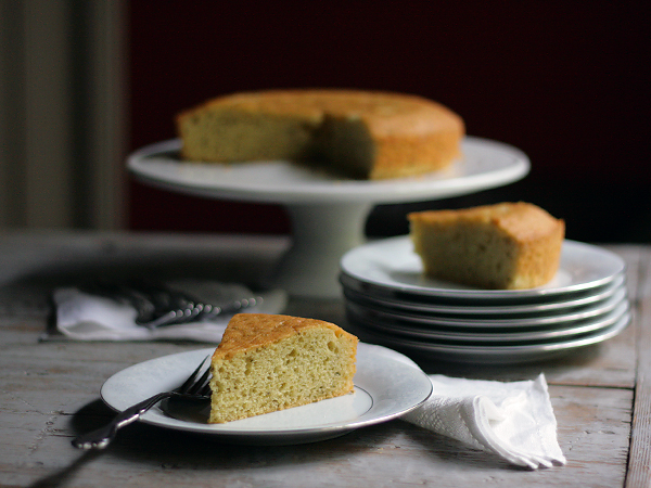 rosemary olive oil cake on cake stand and slices on plates