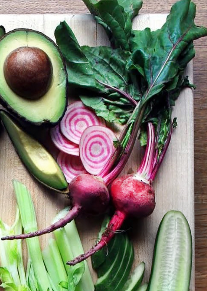 baby candy stripe beets, whole and sliced on wooden cutting board