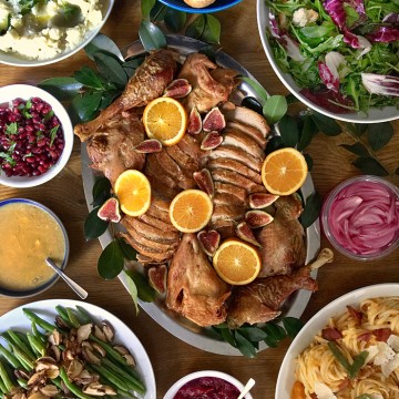 thanksgiving turkey platter with citrus and figs, mashed cauliflower, arugula salad, green beans, butternut carbonara pasta and sauces