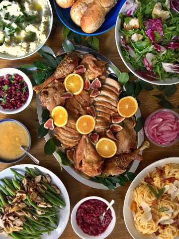 thanksgiving turkey platter with citrus and figs, mashed cauliflower, arugula salad, green beans, butternut carbonara pasta and sauces