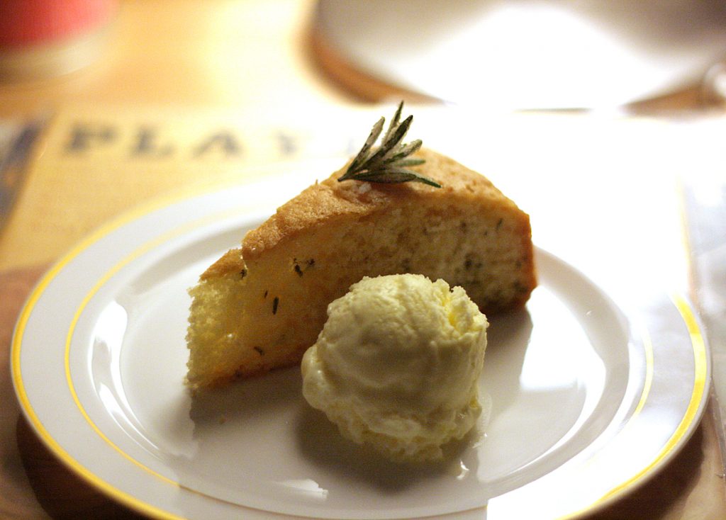 rosemary olive oil cake slice with olive oil ice cream scoop on plate