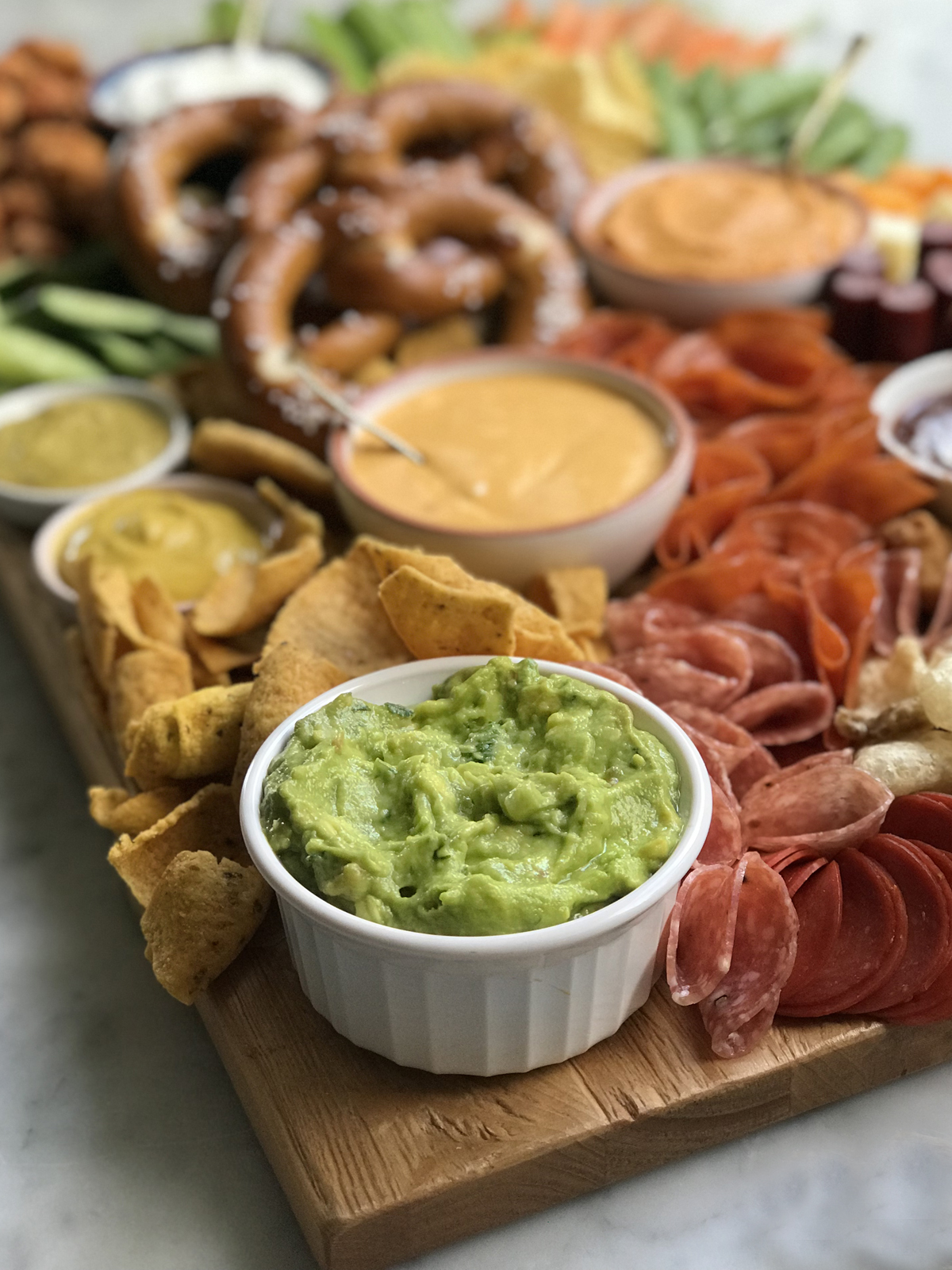 game day cheese and charcuterie board guacamole and queso