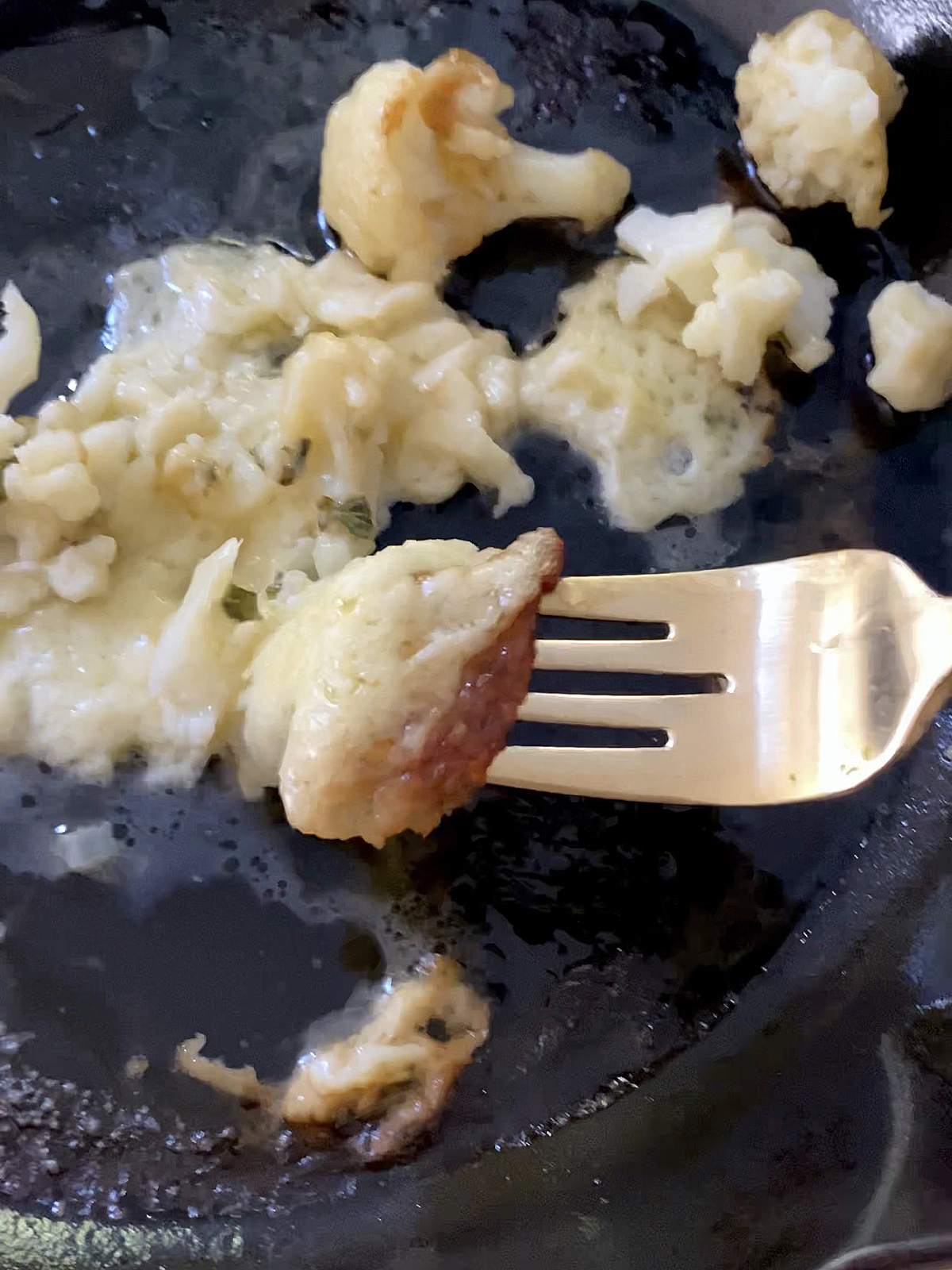 cauliflower florets and burnt cheese in cat iron skillet
