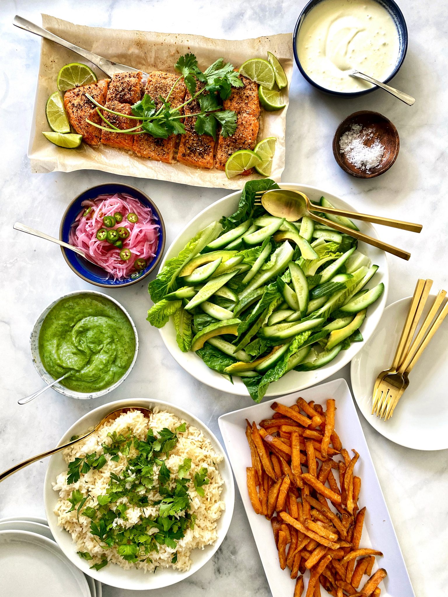 aji verde Peruvian spicy green sauce served with Peruvian roast salmon, avocado cucumber salad, cilantro lime rice, sweet potato french fries, and salsa criolla