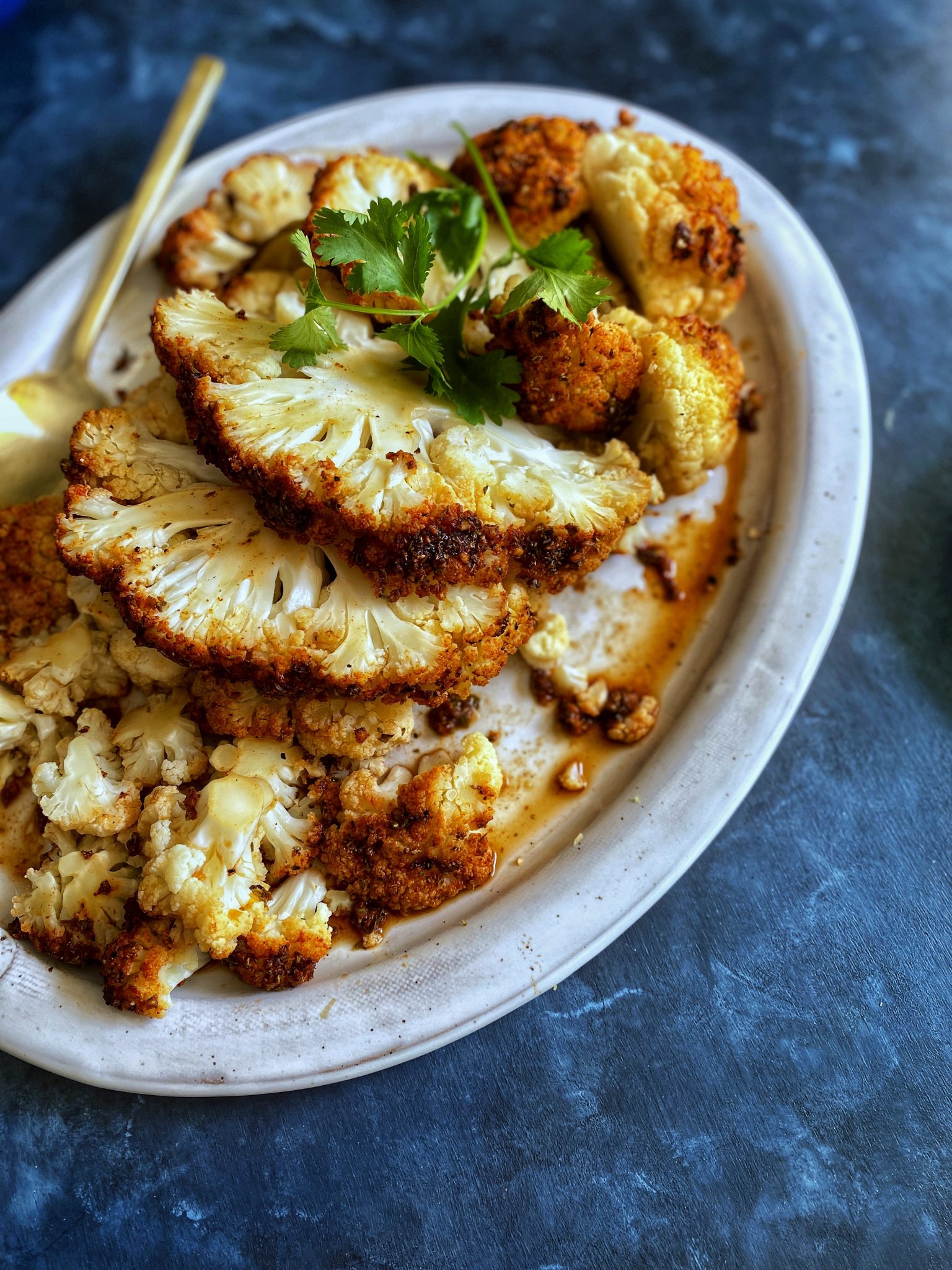 whole roasted cauliflower head, sliced on platter, peruvian pollo a la brasa marinade