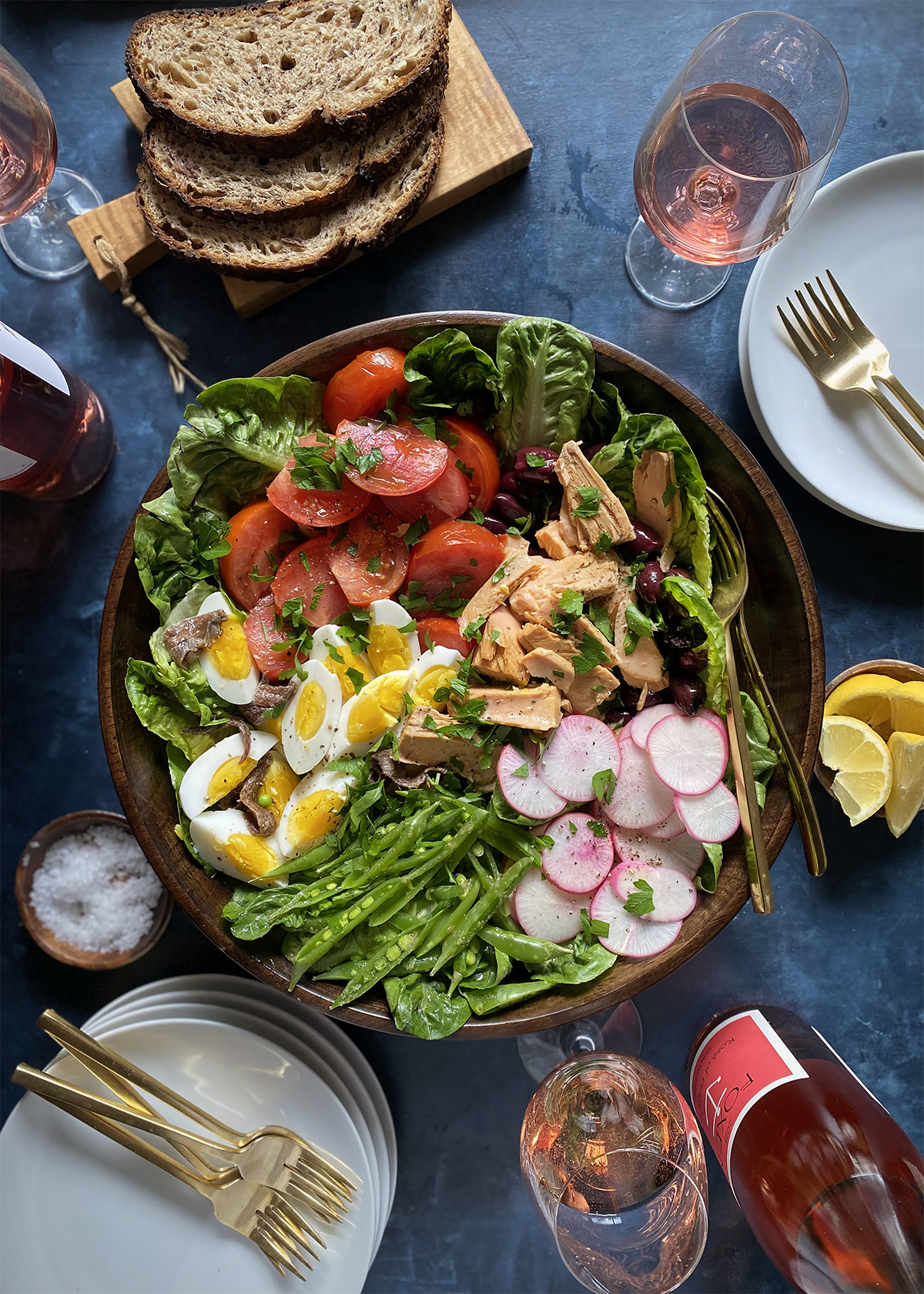 nicoise salad wooden bowl and wine