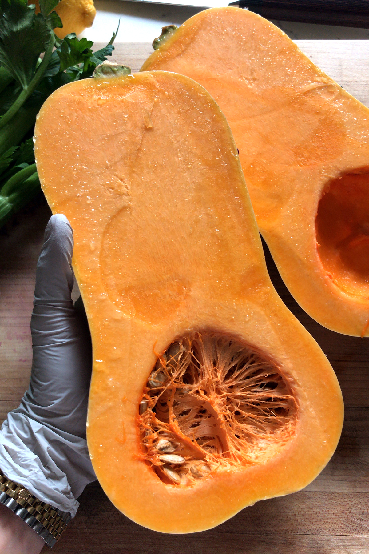 butternut squash cut in half, held with gloved hand