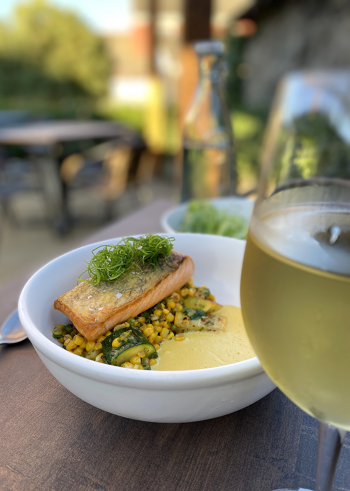 seared salmon with crispy skin on corn and summer squash, paired with white wine