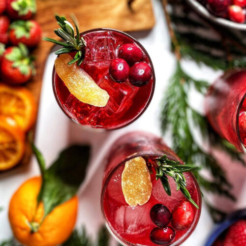 cranberry moscow mule with cranberries ginger and rosemary in glasses