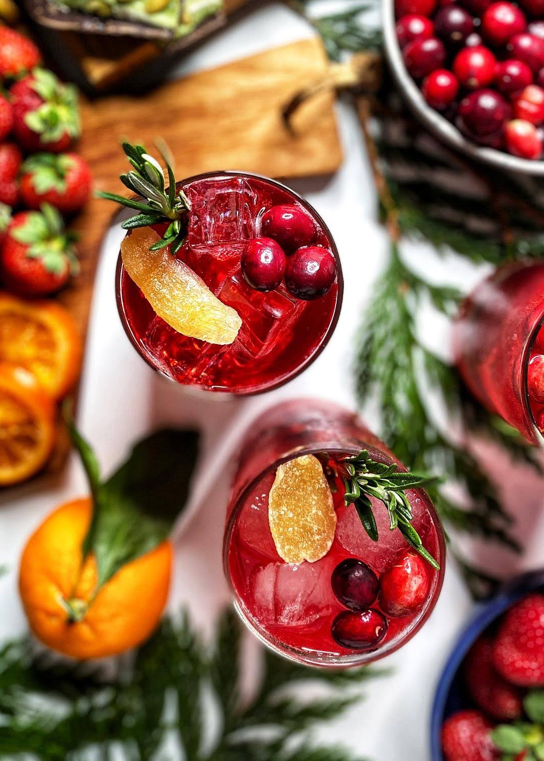 cranberry moscow mule with cranberries ginger and rosemary in glasses