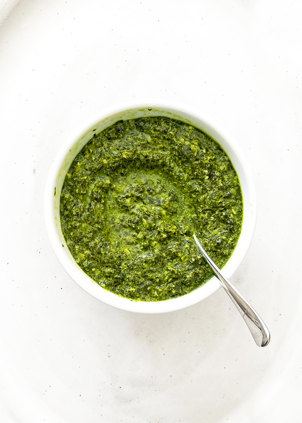 kale pesto in bowl on white table background