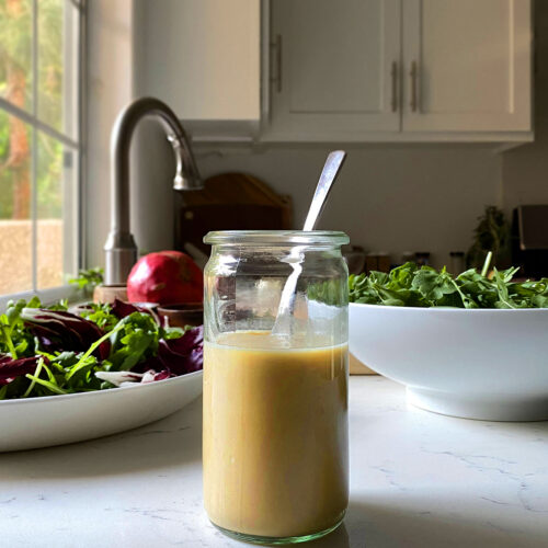 maple mustard dressing in jar on white marble kitchen countertop