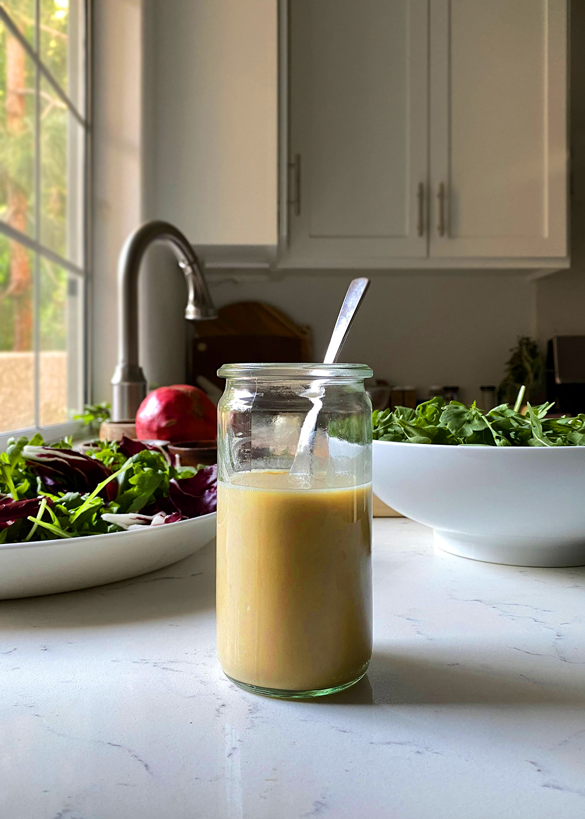 maple mustard dressing in jar on white marble kitchen countertop