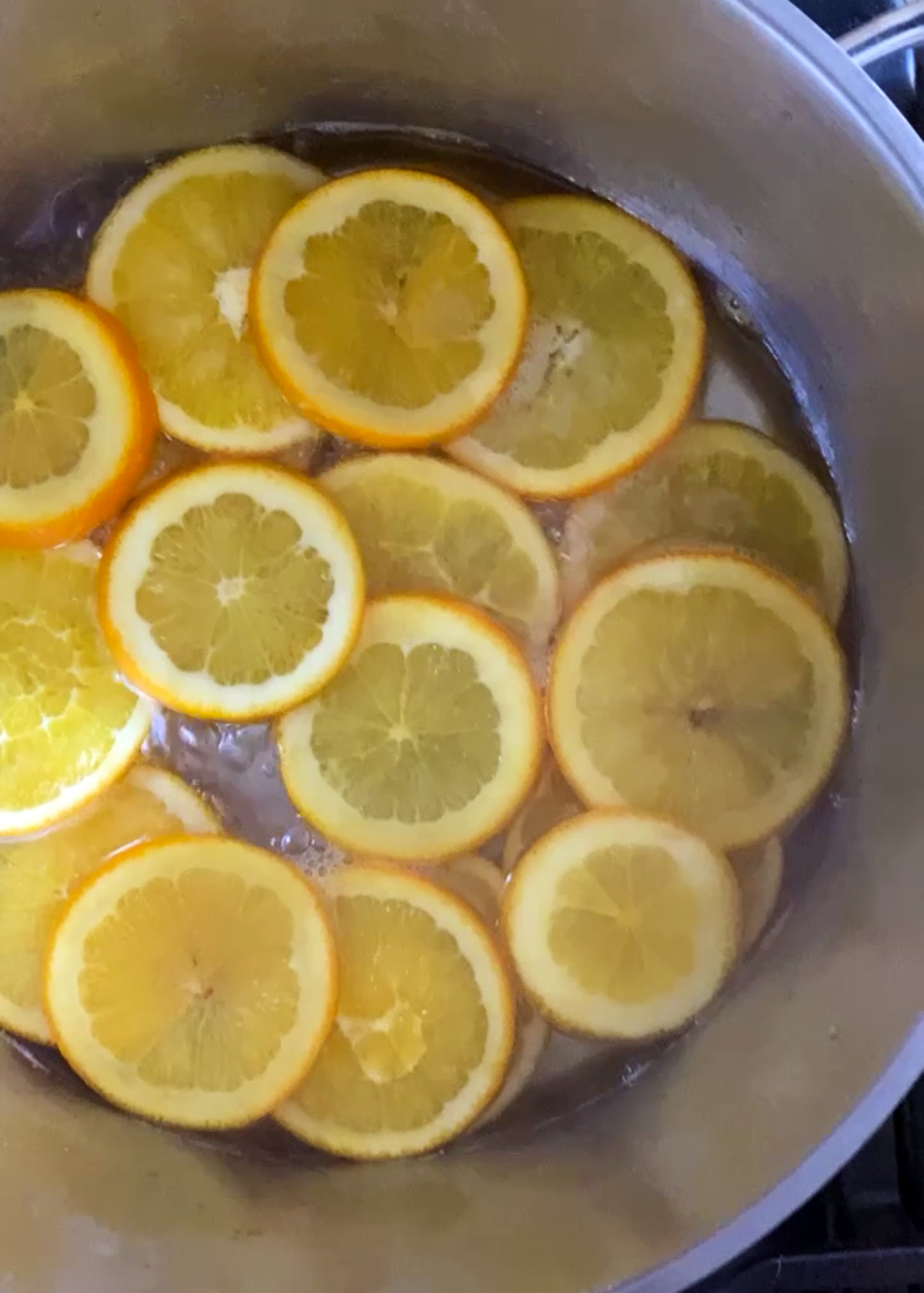 orange slices boiling in stainless steel pot