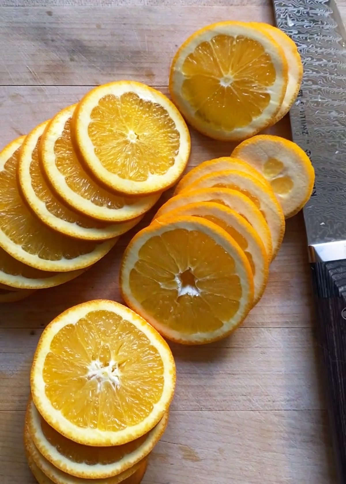 ¼-inch orange slices on wooden cutting board
