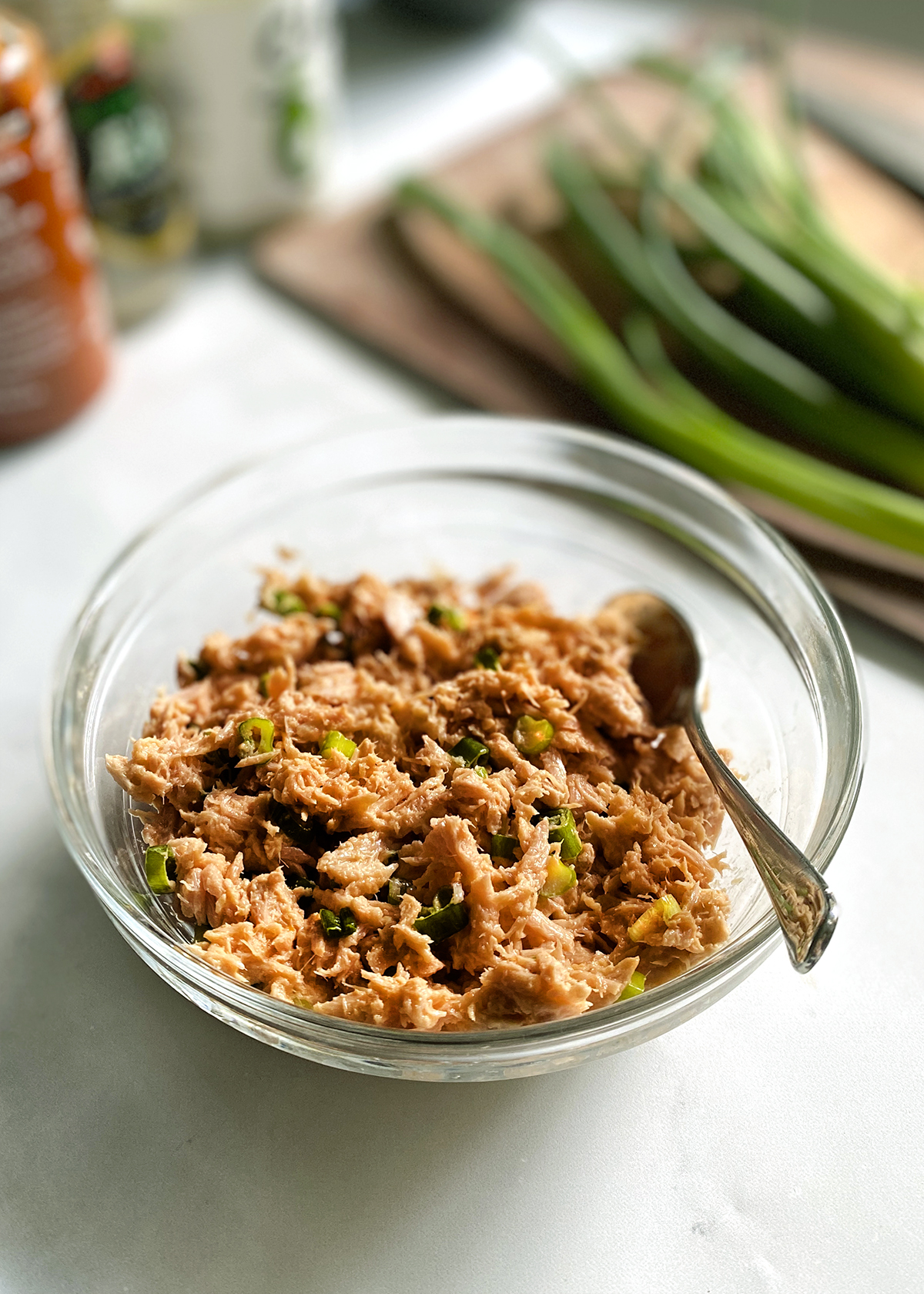 spicy tuna with canned tuna in glass mixing bowl