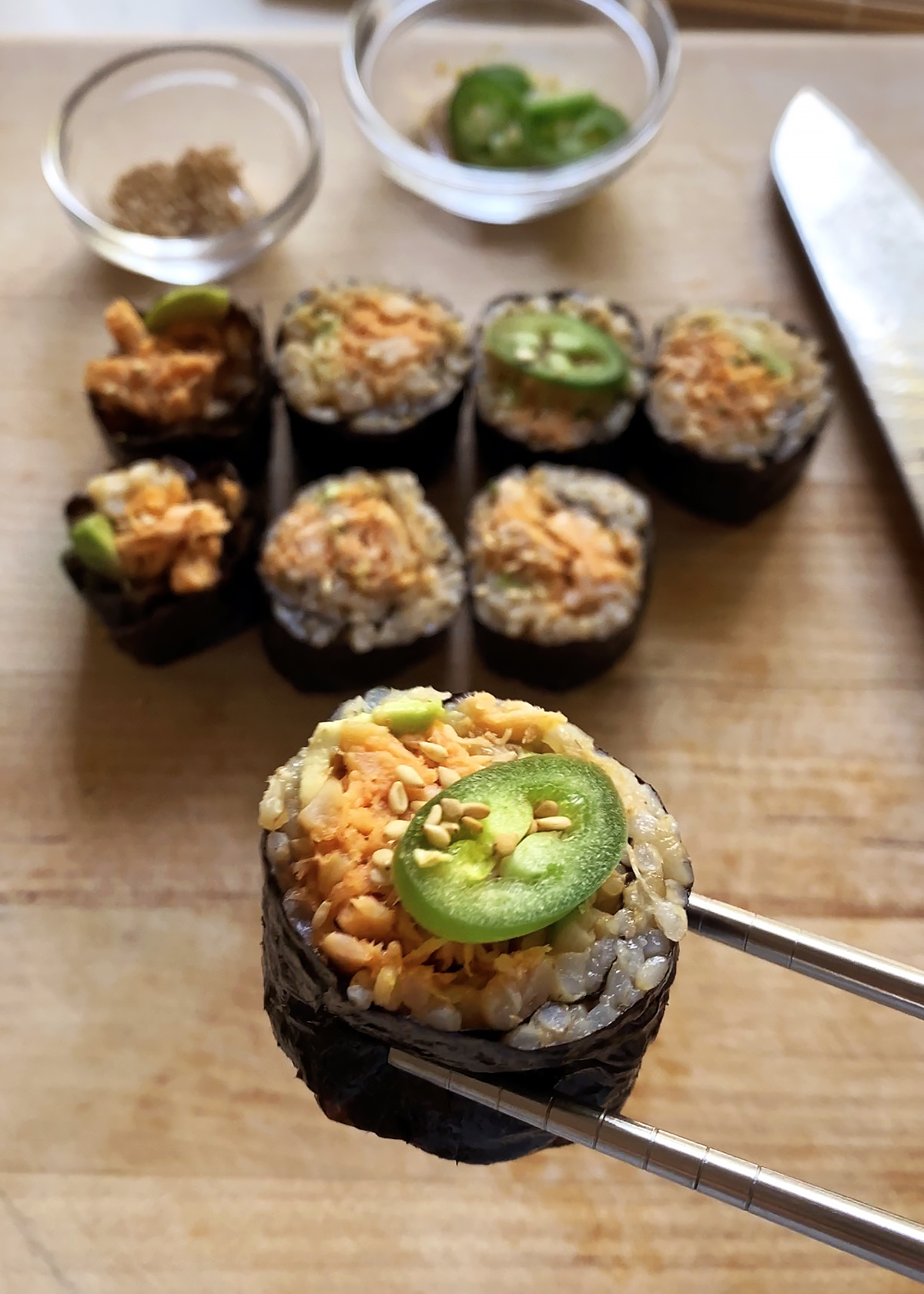 spicy tuna roll piece with serrano pepper, chopsticks