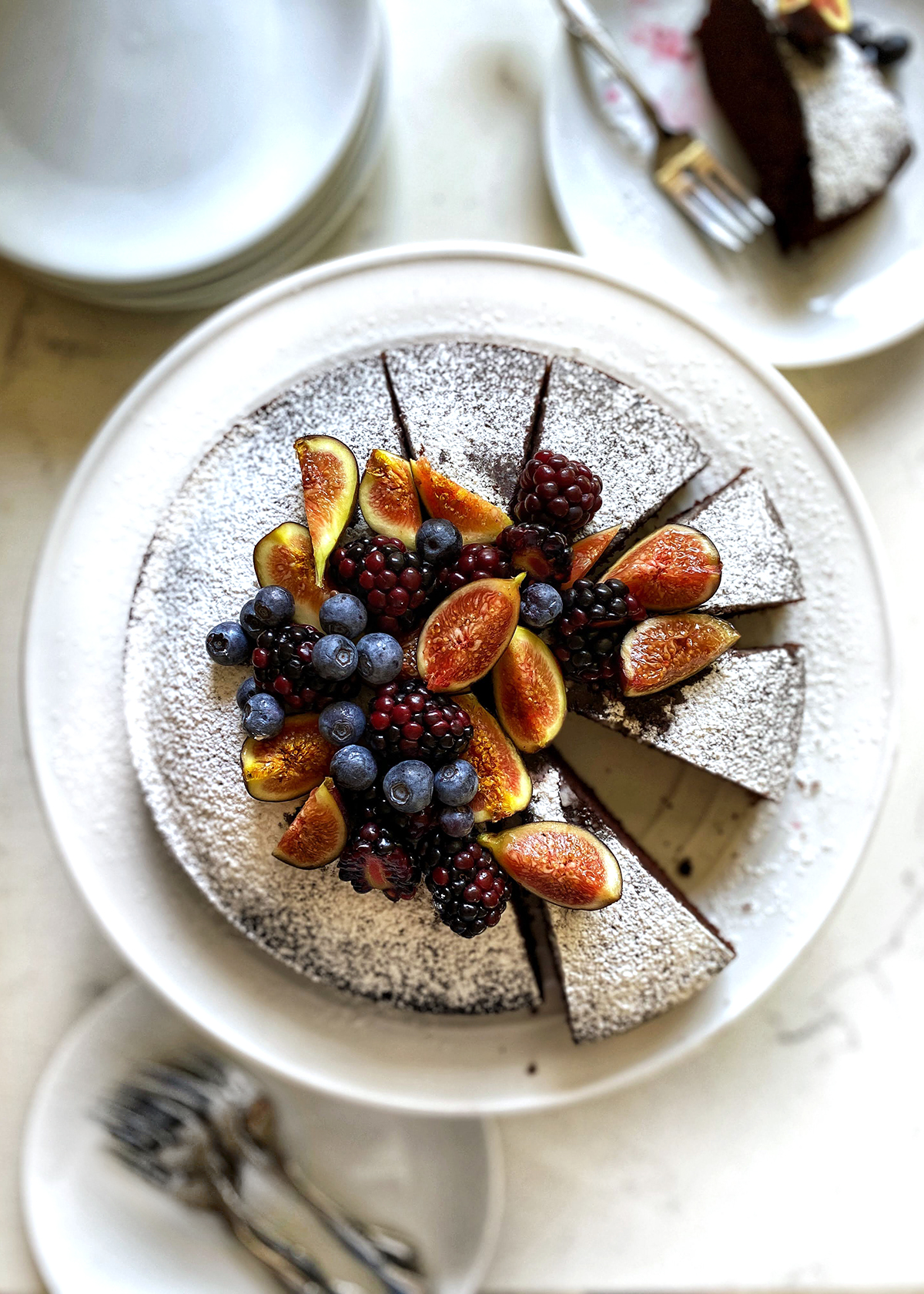 chocolate olive oil cake dusted with powdered sugar and berries on top