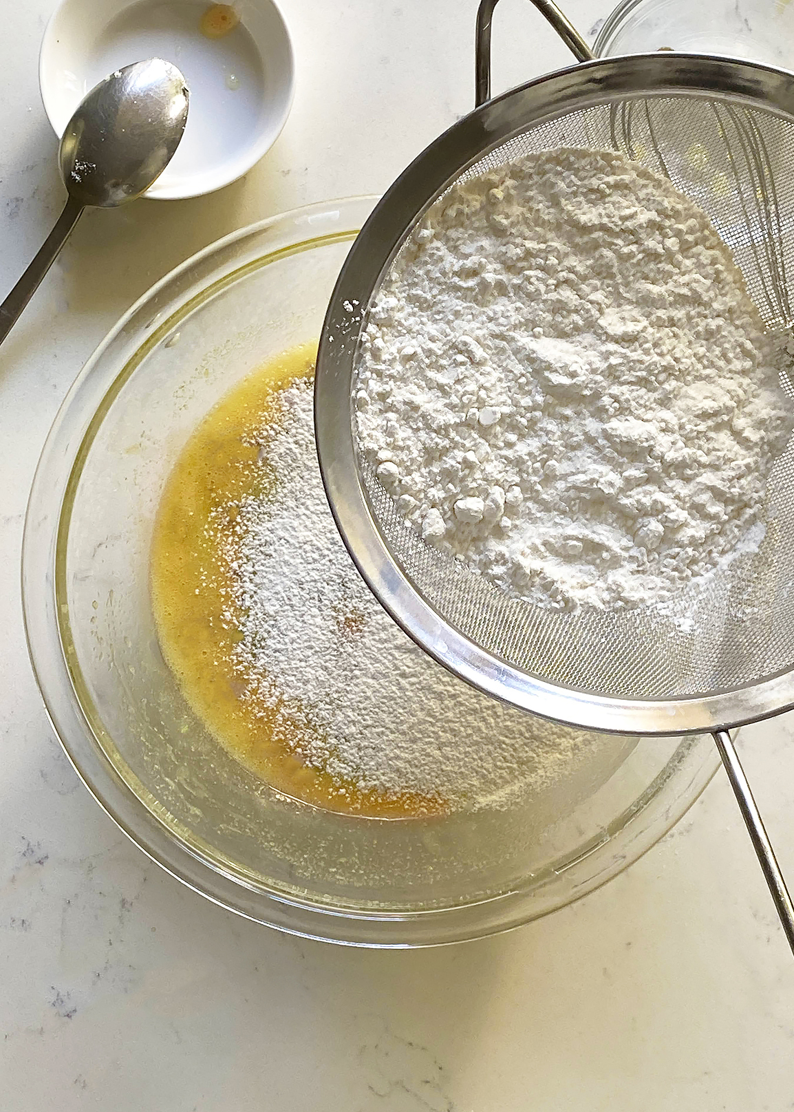 sifting dry ingredients into liquid ingredients, olive oil cake batter