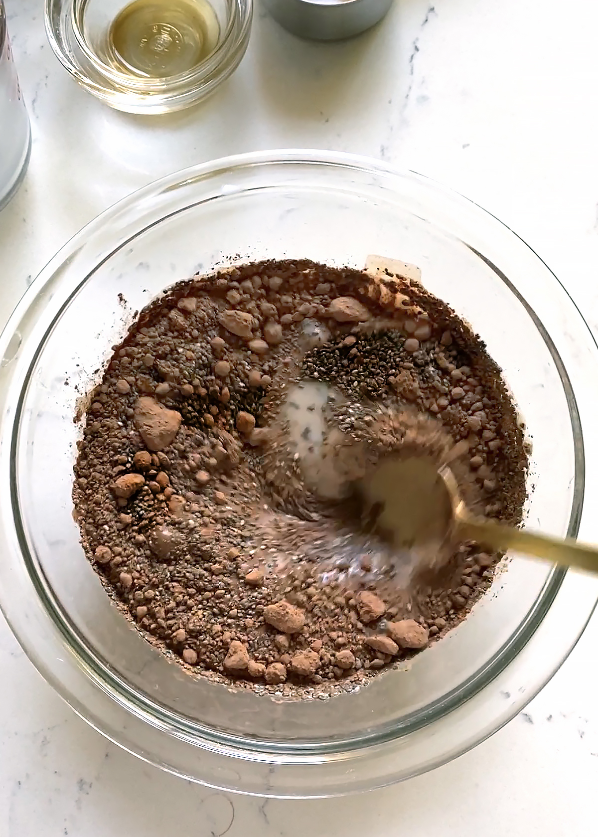 chocolate chia seed pudding ingredients stirring together in glass bowl
