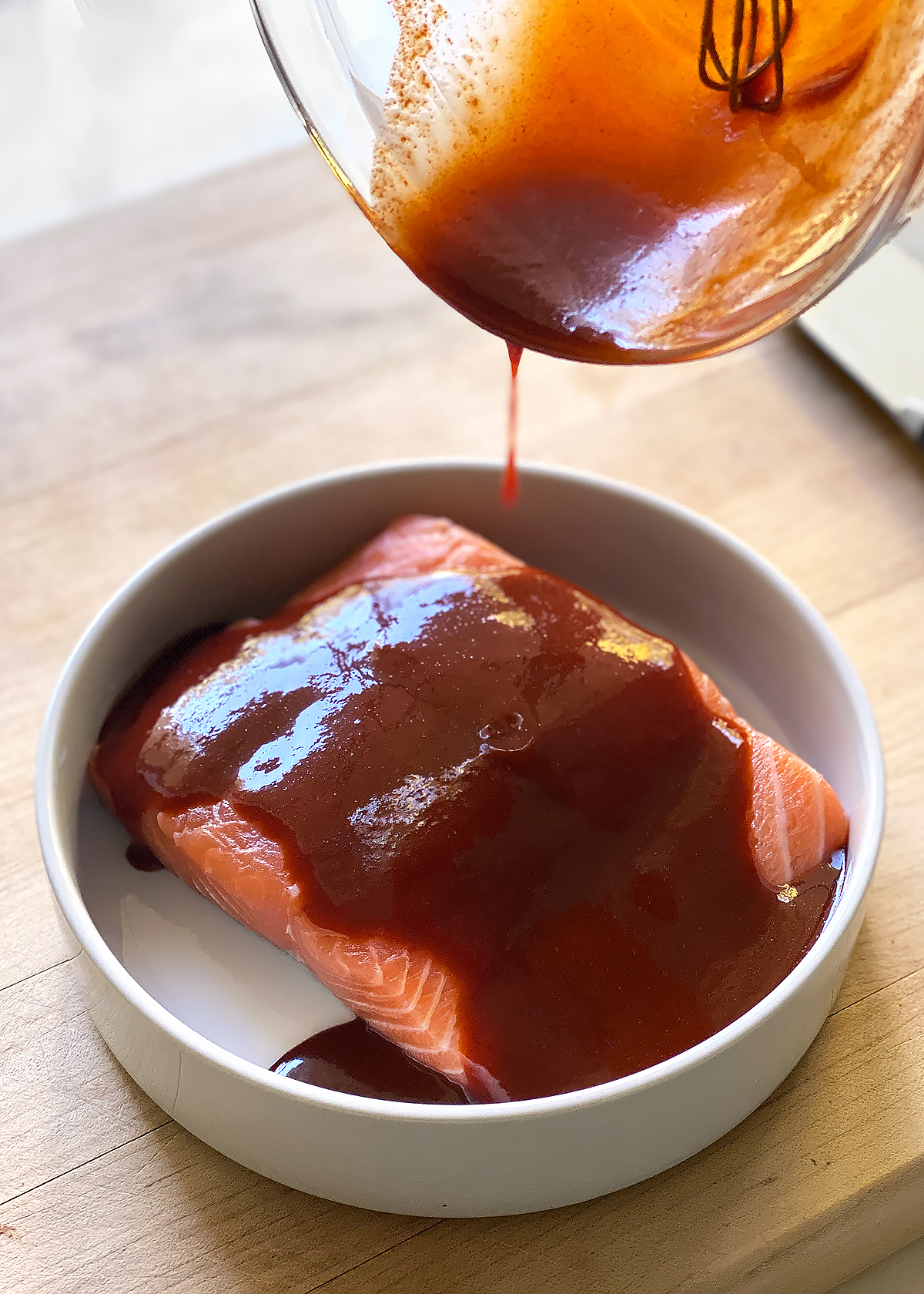 spicy gochujang marinade pouring over salmon