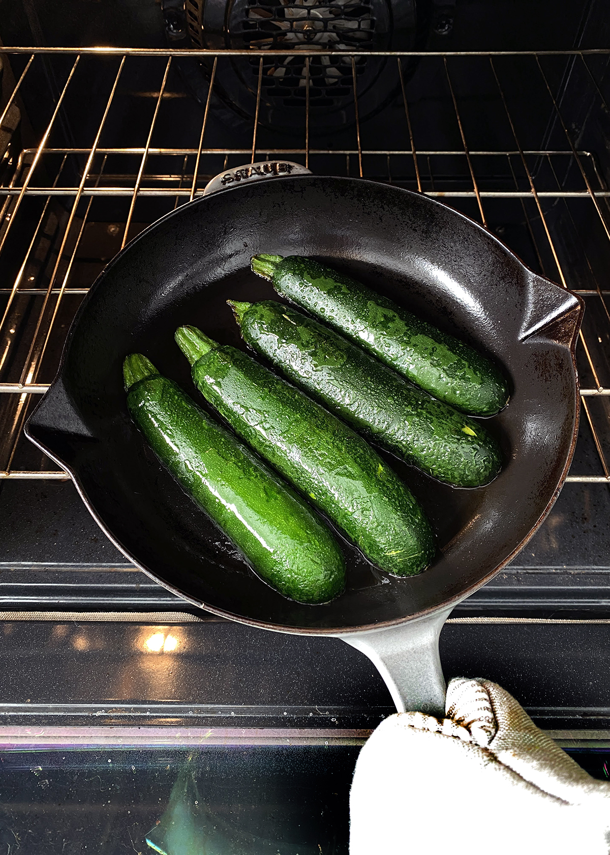 oven roasted zucchini sliced lengthwise, placed cut-side down in cast iron skillet going into oven
