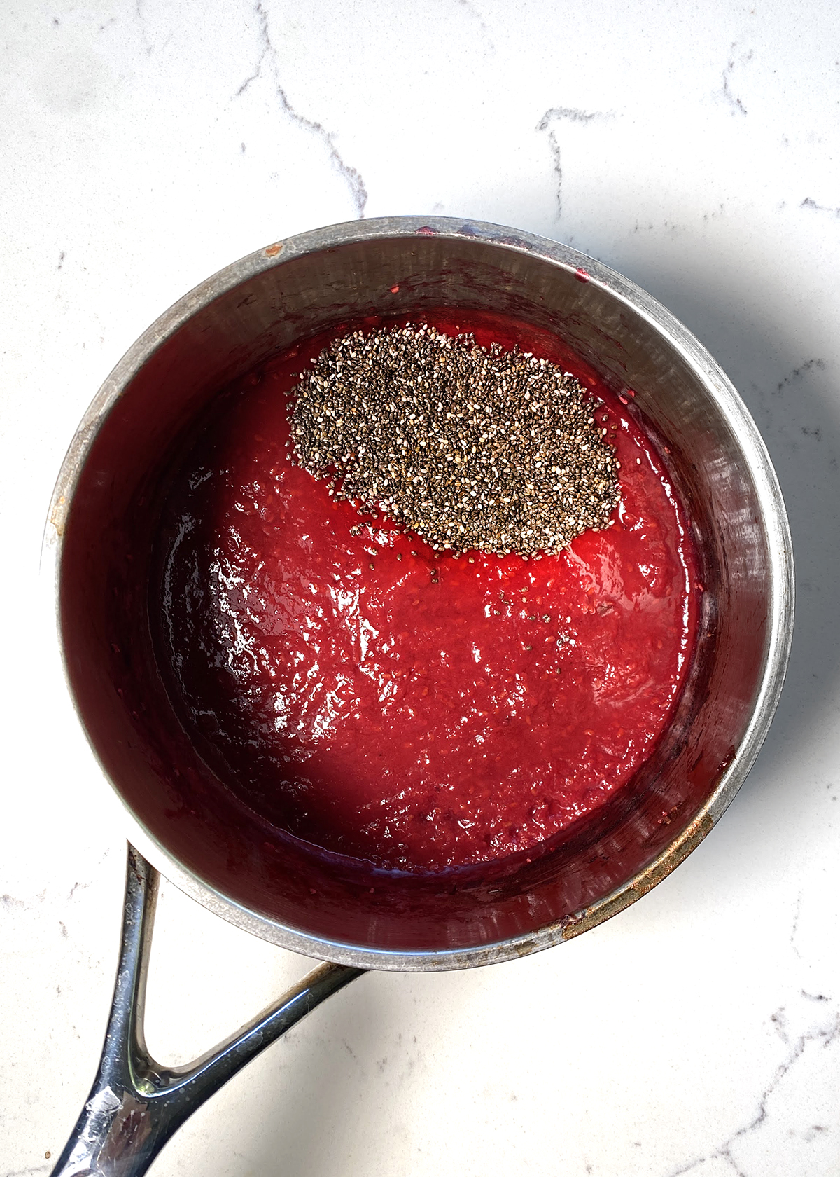 raspberries and chia seeds in saucepot for chia seed jam