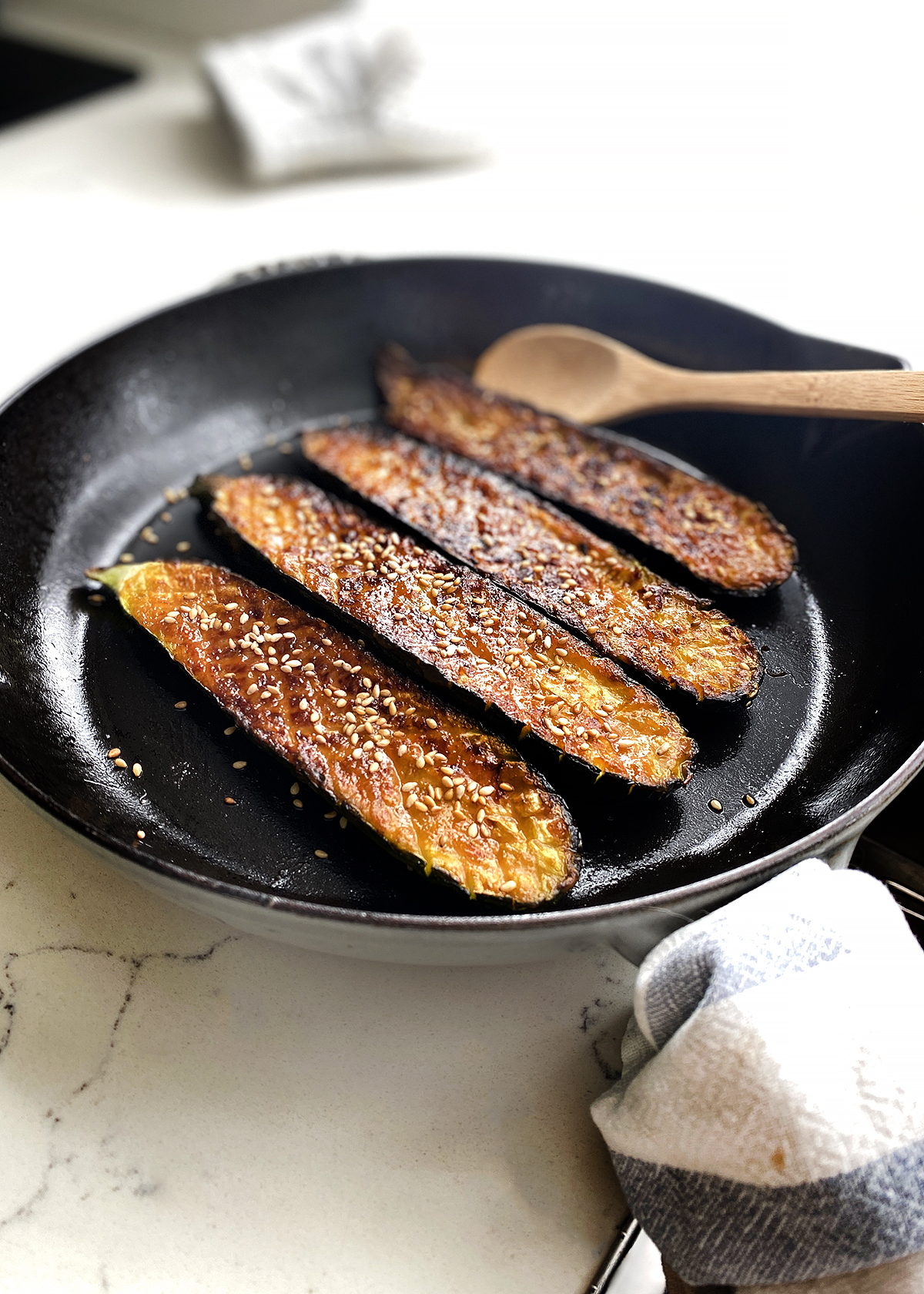 oven roasted zucchini with glaze and sesame seeds in cast iron skillet