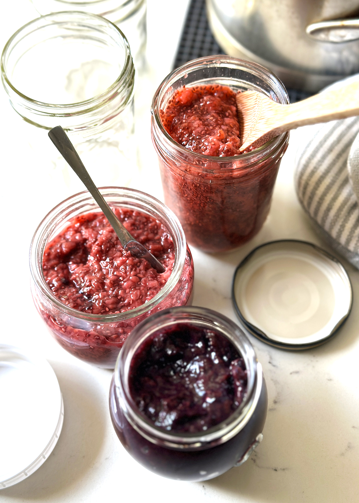 spooning berry chia jams into jars