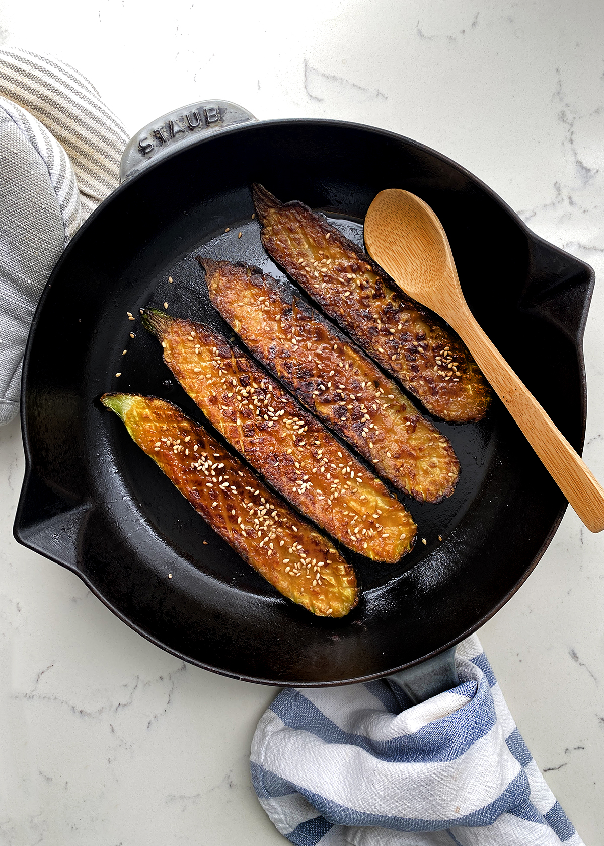 oven roasted zucchini sliced lengthwise, and cut thomas keller style, in cast iron skillet on countertop