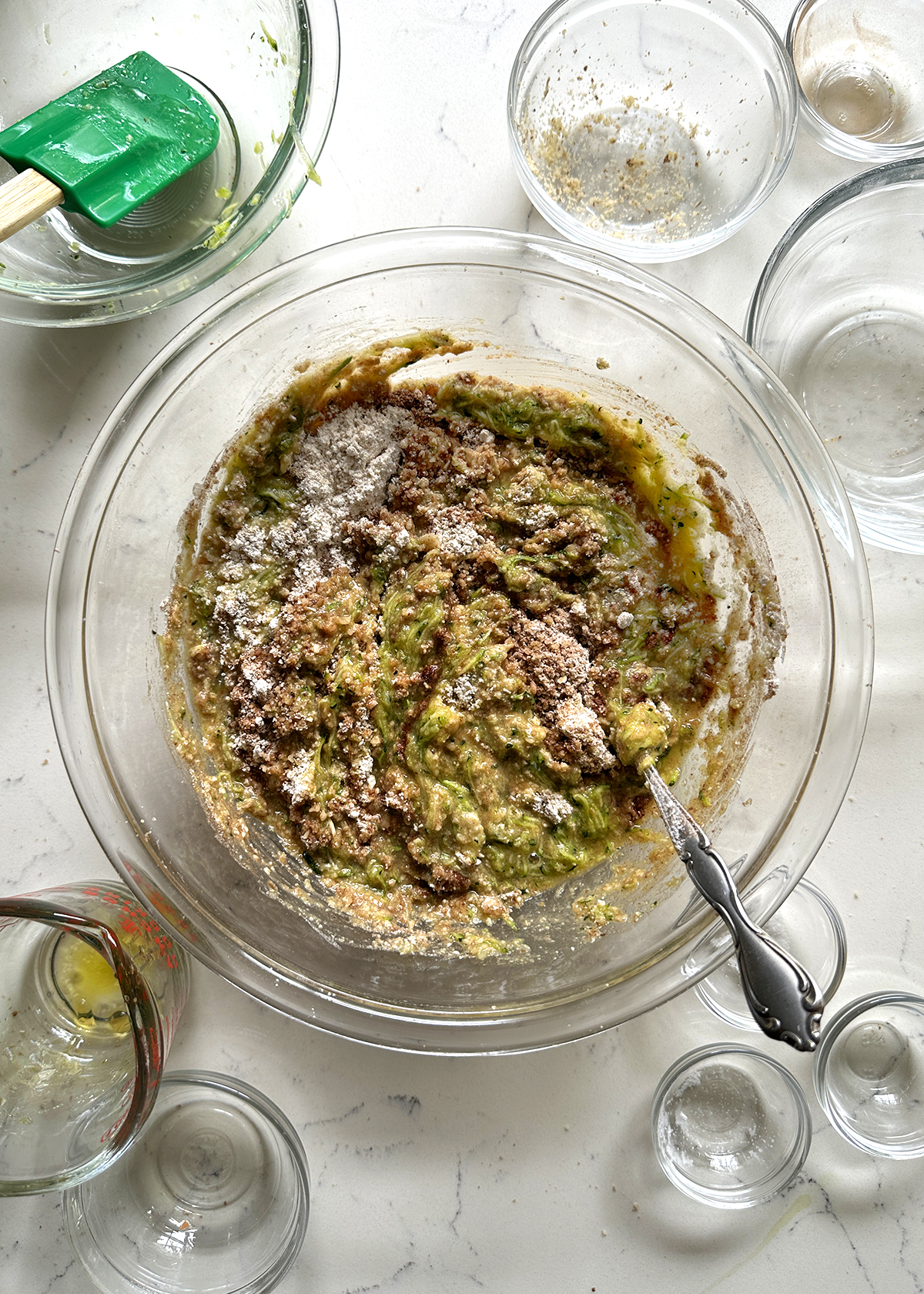 dry ingredients mixed into wet ingredients in glass mixing bowl