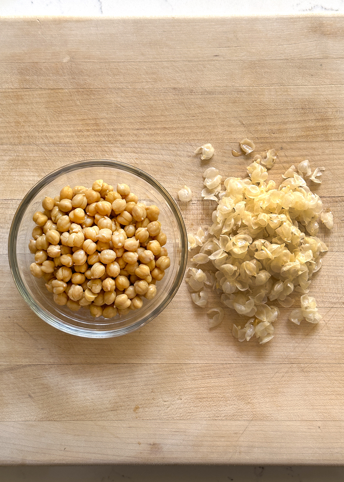 canned chickpeas in glass bowl, thin skins peeled off