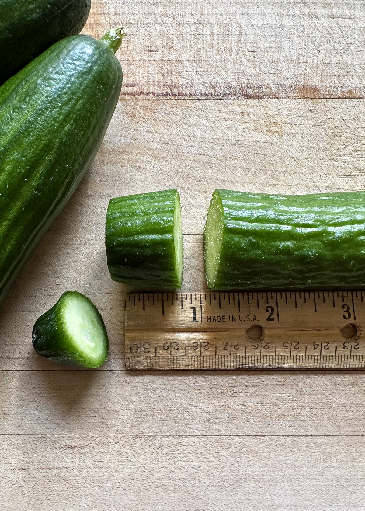 slicing cucumbers ¾-inch thick next to ruler