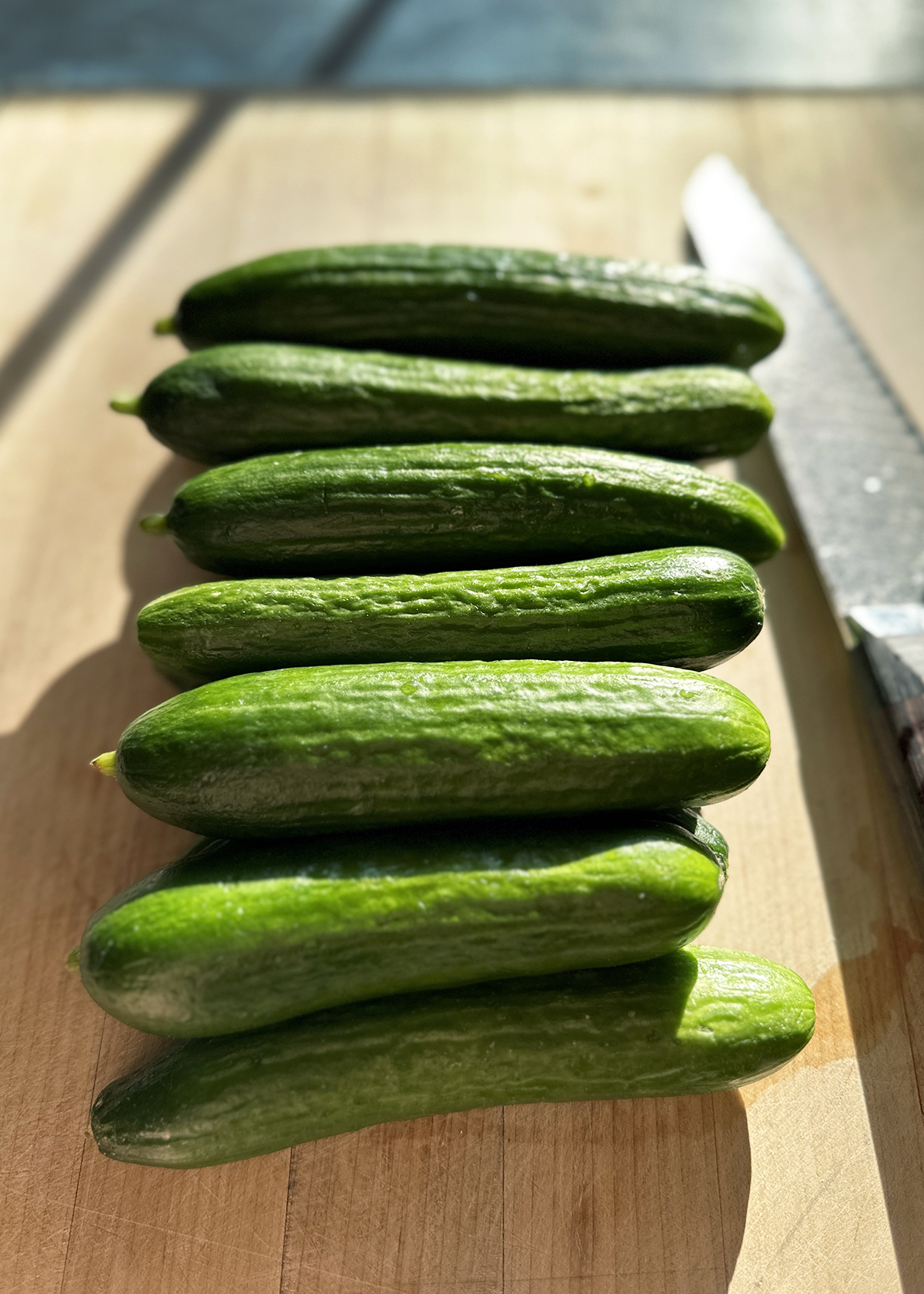 persian cucumbers on wooden cutting board