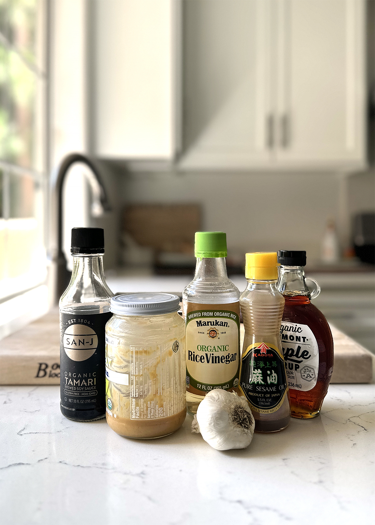 peanut sauce ingredients bottles on marble countertop
