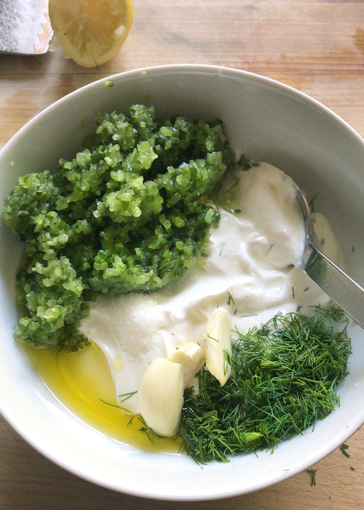 cucumber, garlic yogurt and herbs in bowl for tzatziki