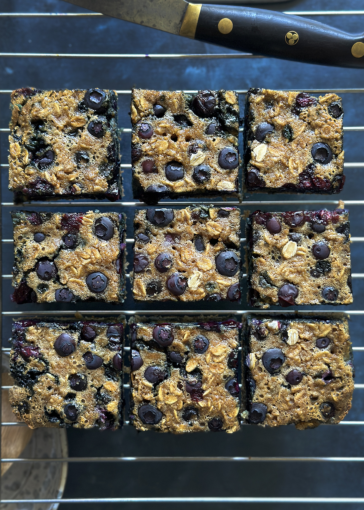 Sliced blueberry muffin baked oatmeal squares on cooling rack