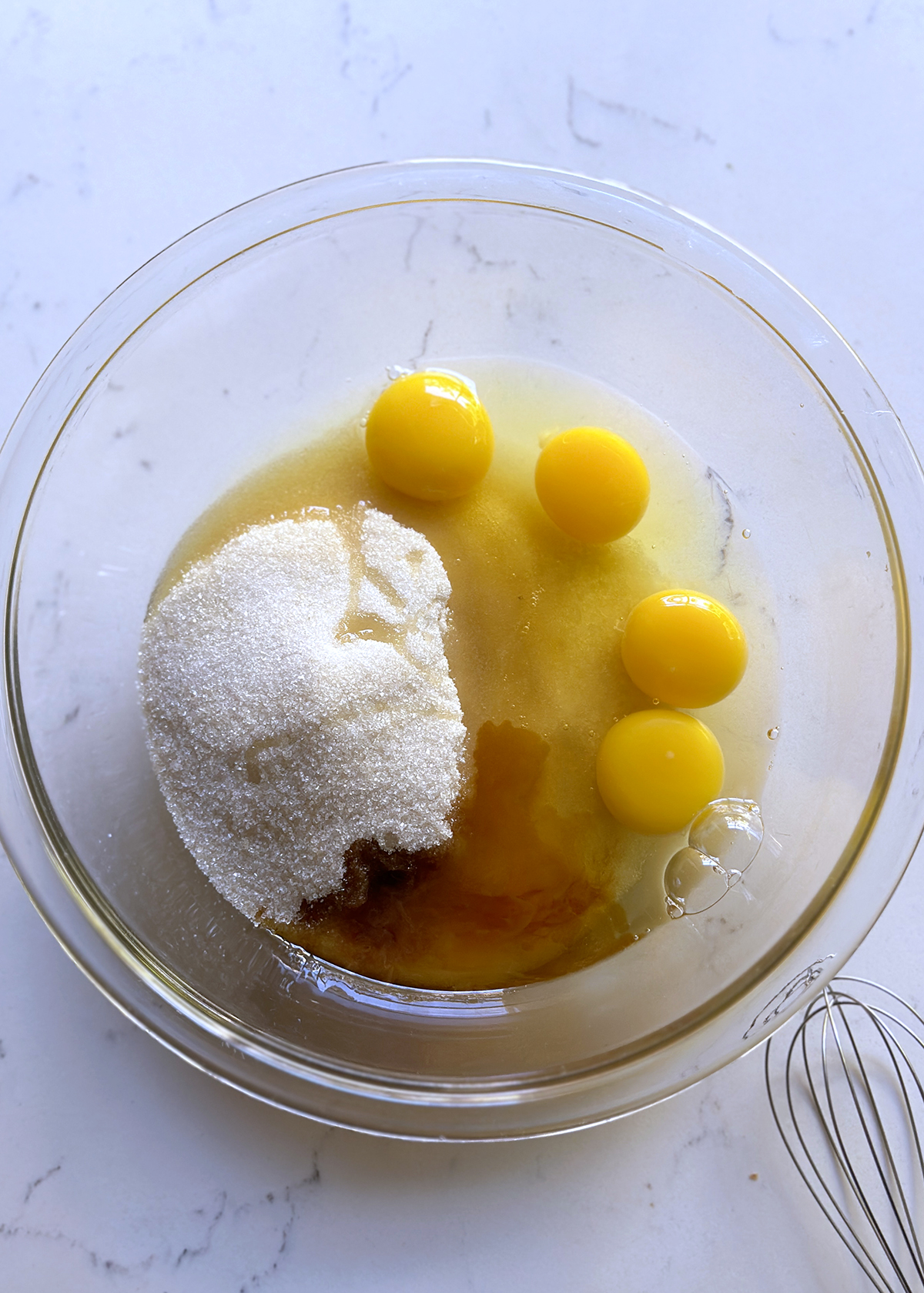 eggs sugar vanilla in glass mixing bowl