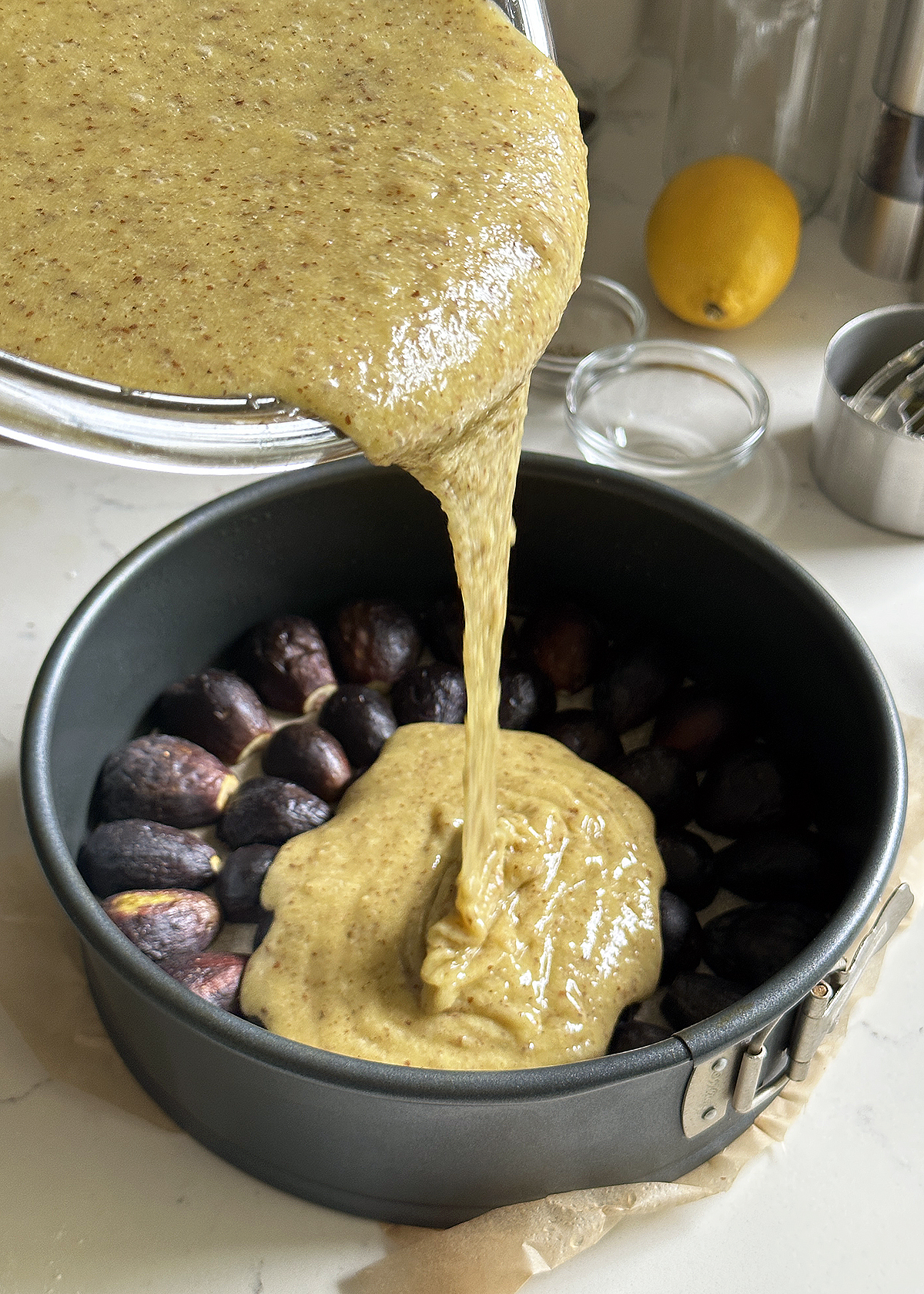walnut olive oil cake batter pouring over figs into cake pan