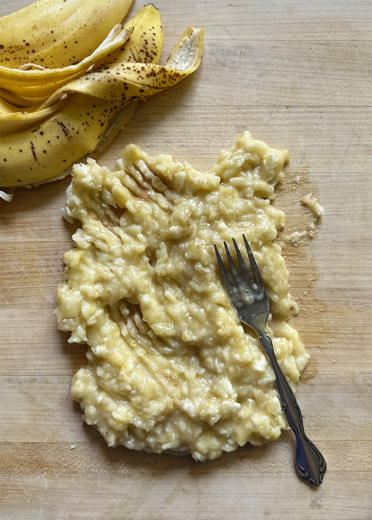 bananas smashed on cutting board for banana bread