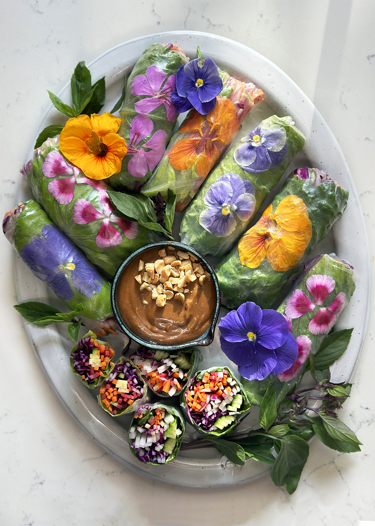 spring rolls with flowers on white platter