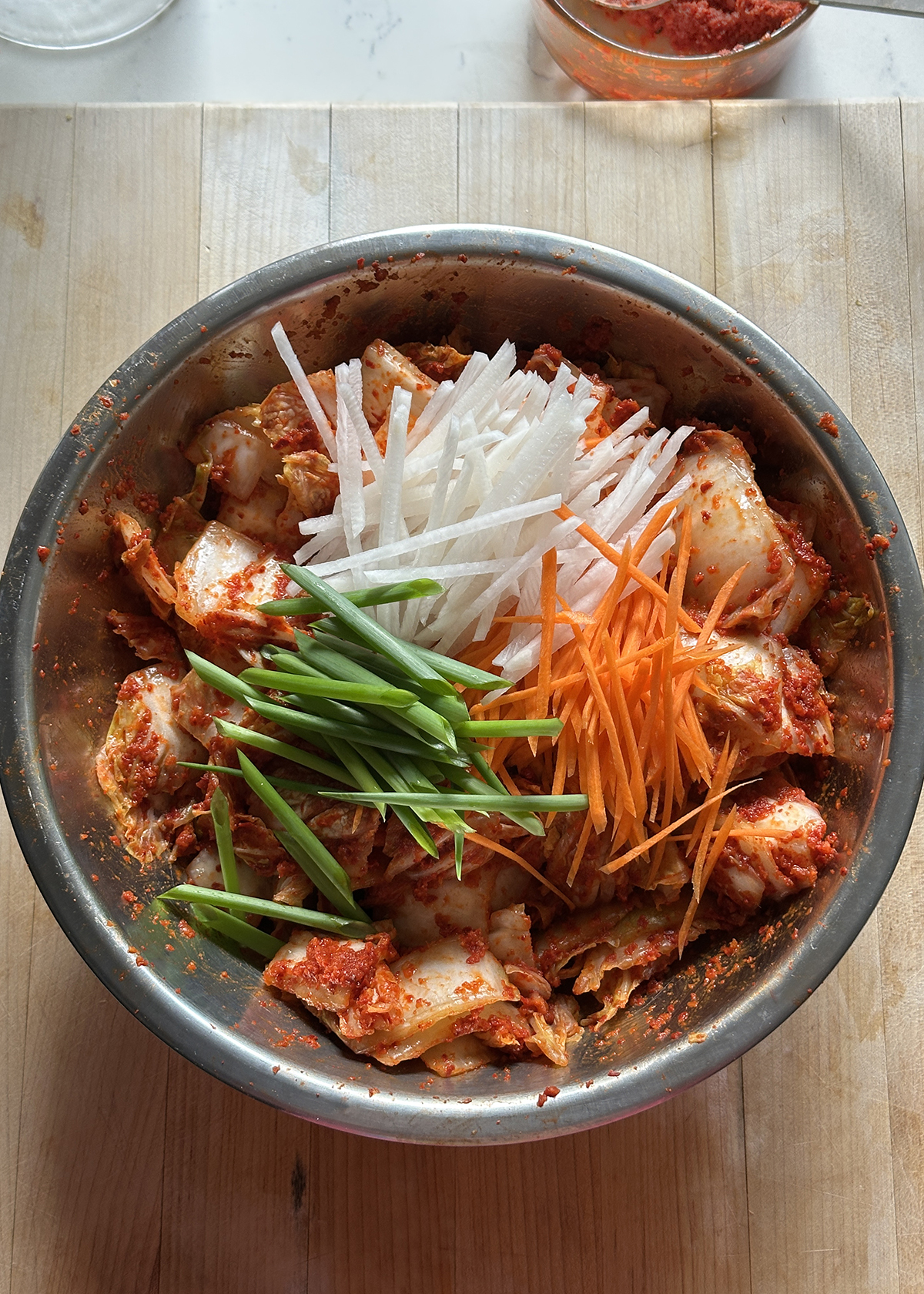 adding carrots, green onions, radish to kimchi