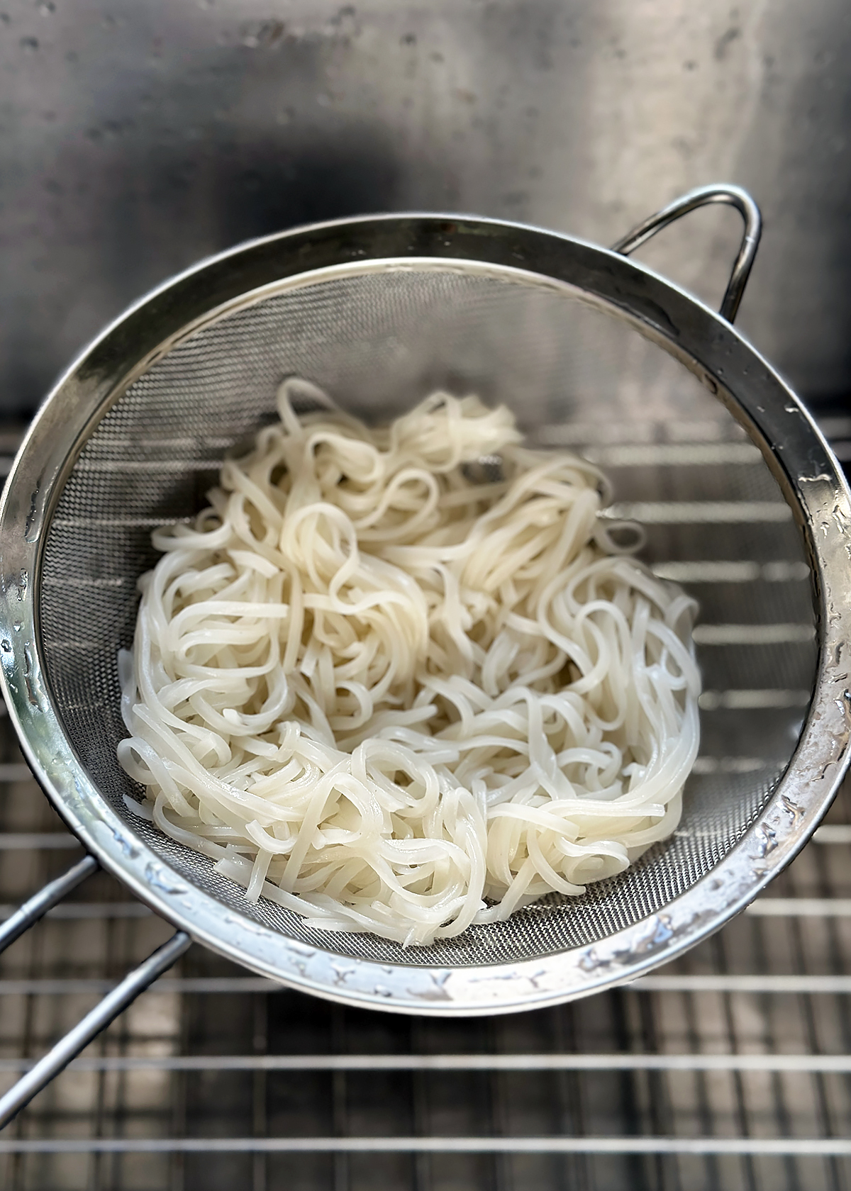 draining cooked rice noodles