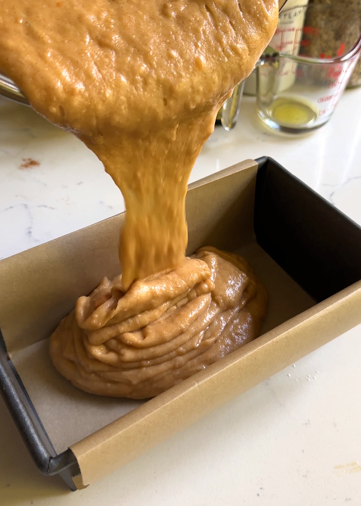persimmon bread batter pouring into pan