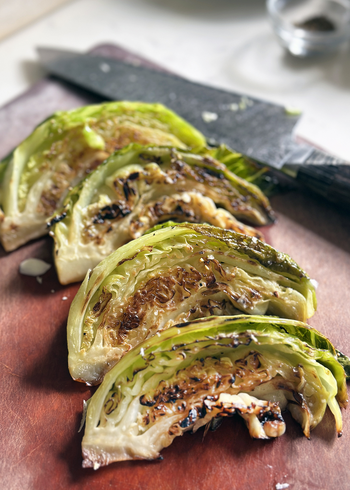 charred cabbage wedges on cutting board