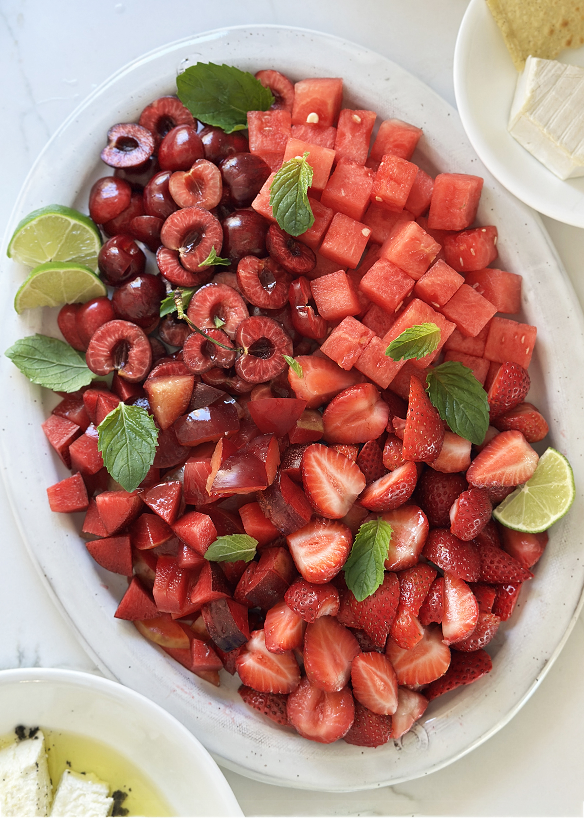 summer red fruits prepped: cherries, watermelon, strawberries, plums