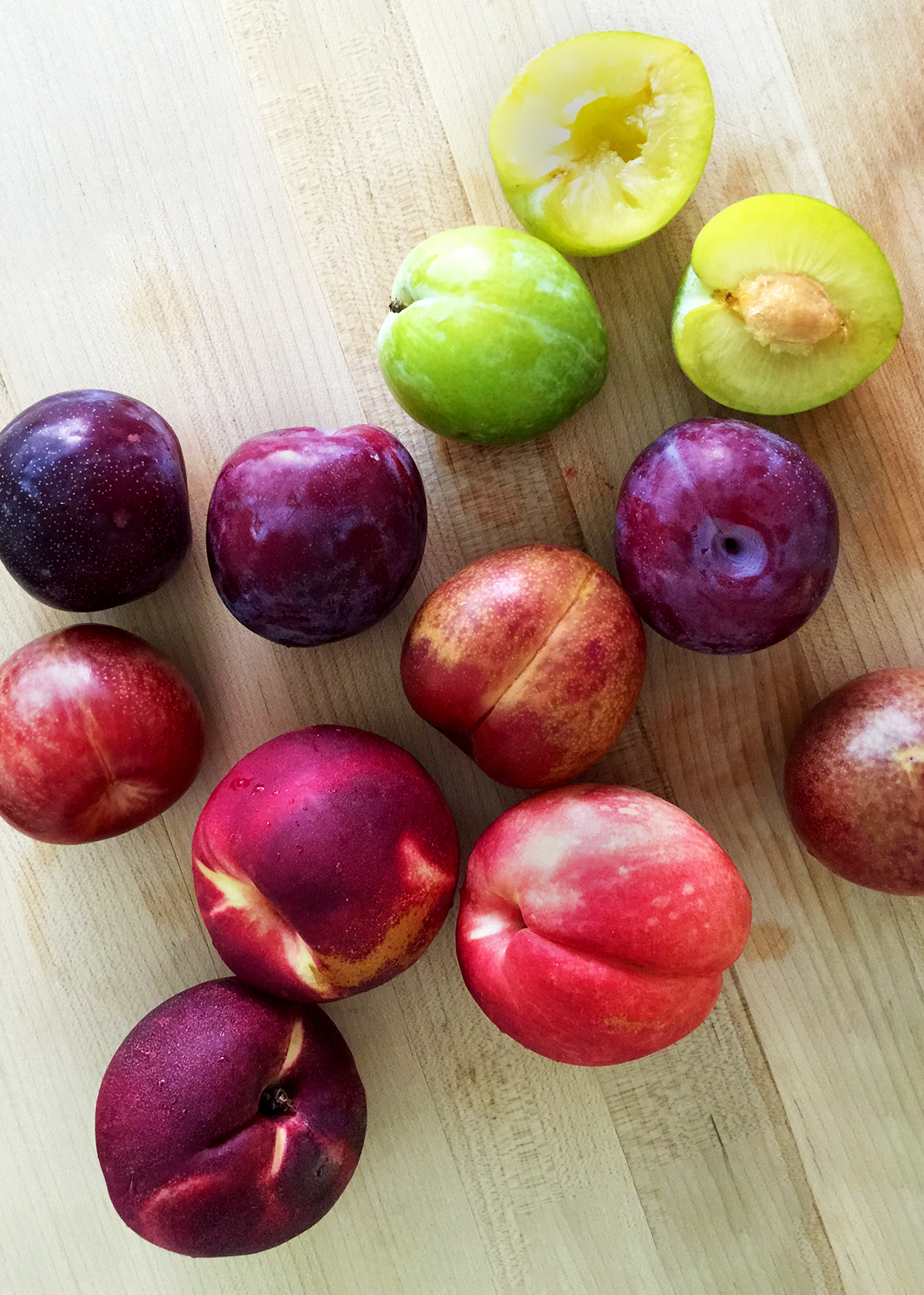 plums and peaches on cutting board